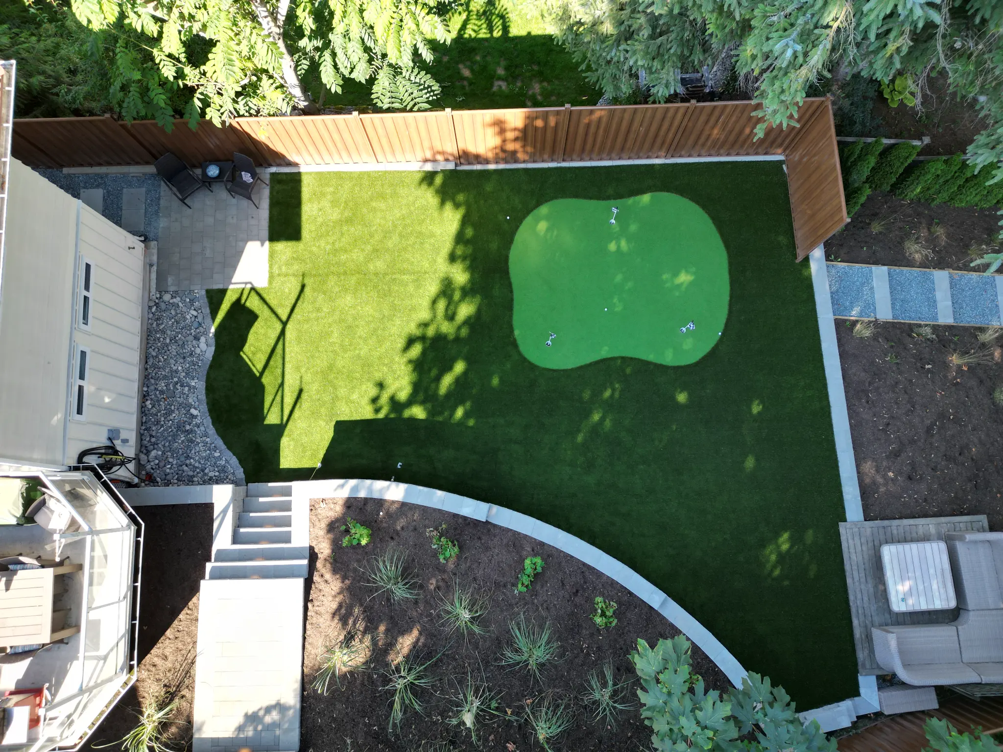 Top-down view of the finished turf, putting surface, patio, and planting beds