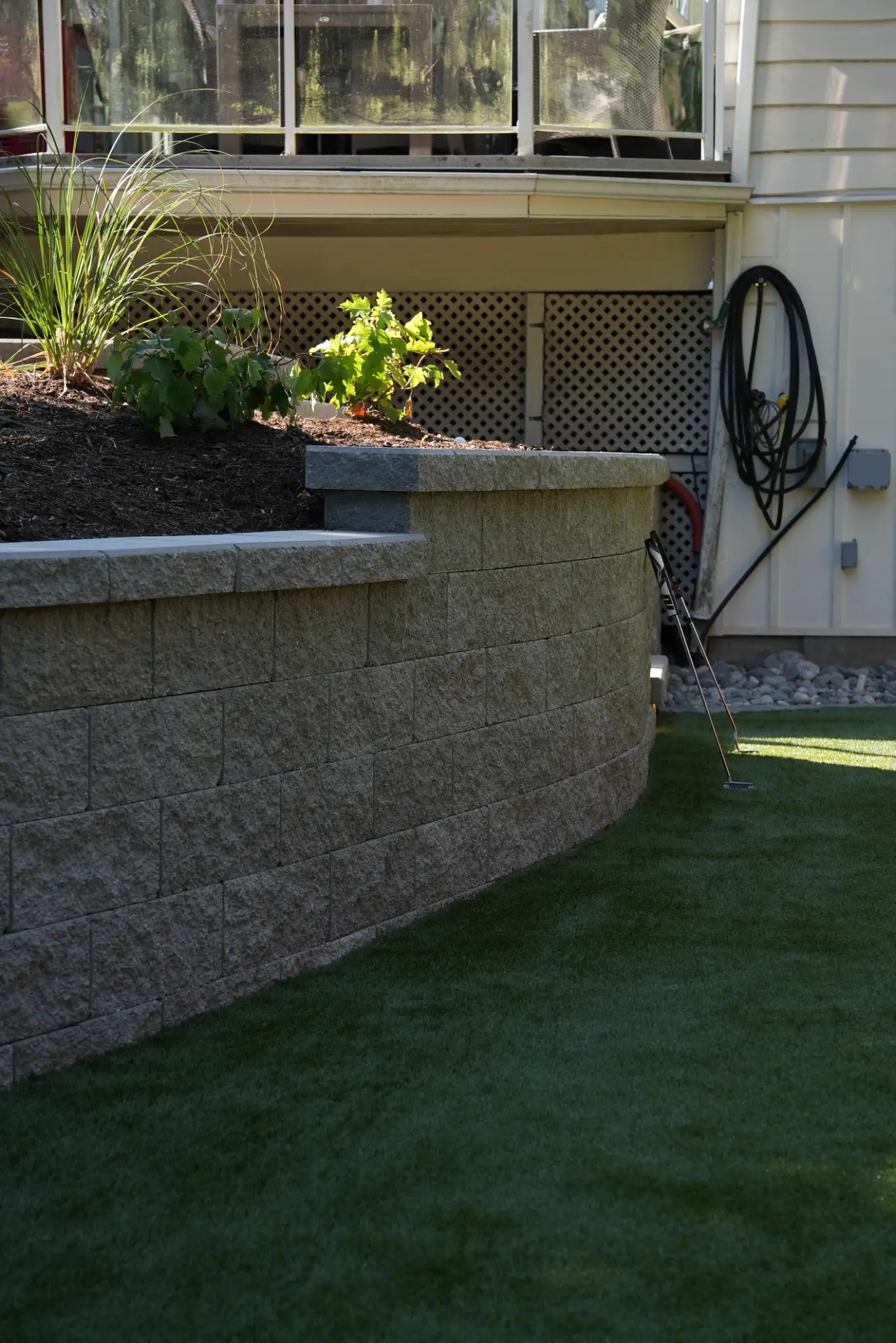 Close view of the curved modular retaining wall beside the putting green