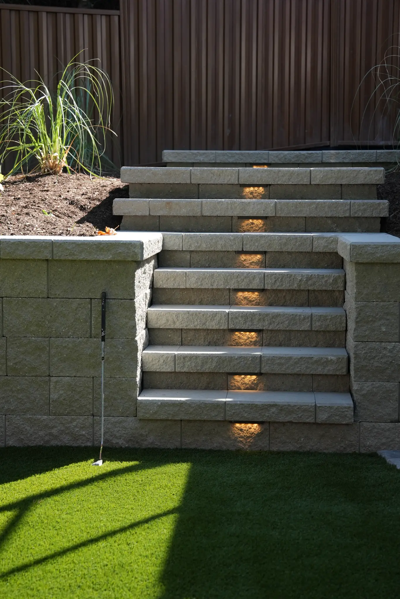 Retaining-wall stairs with integrated lighting beside the artificial turf