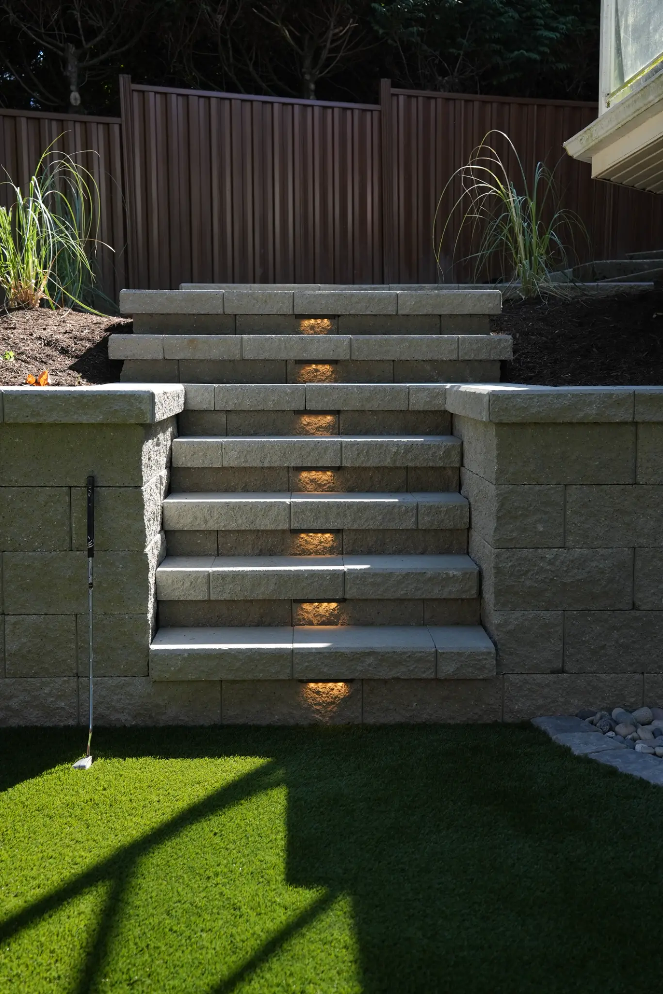 Finished illuminated stairway connecting the backyard levels