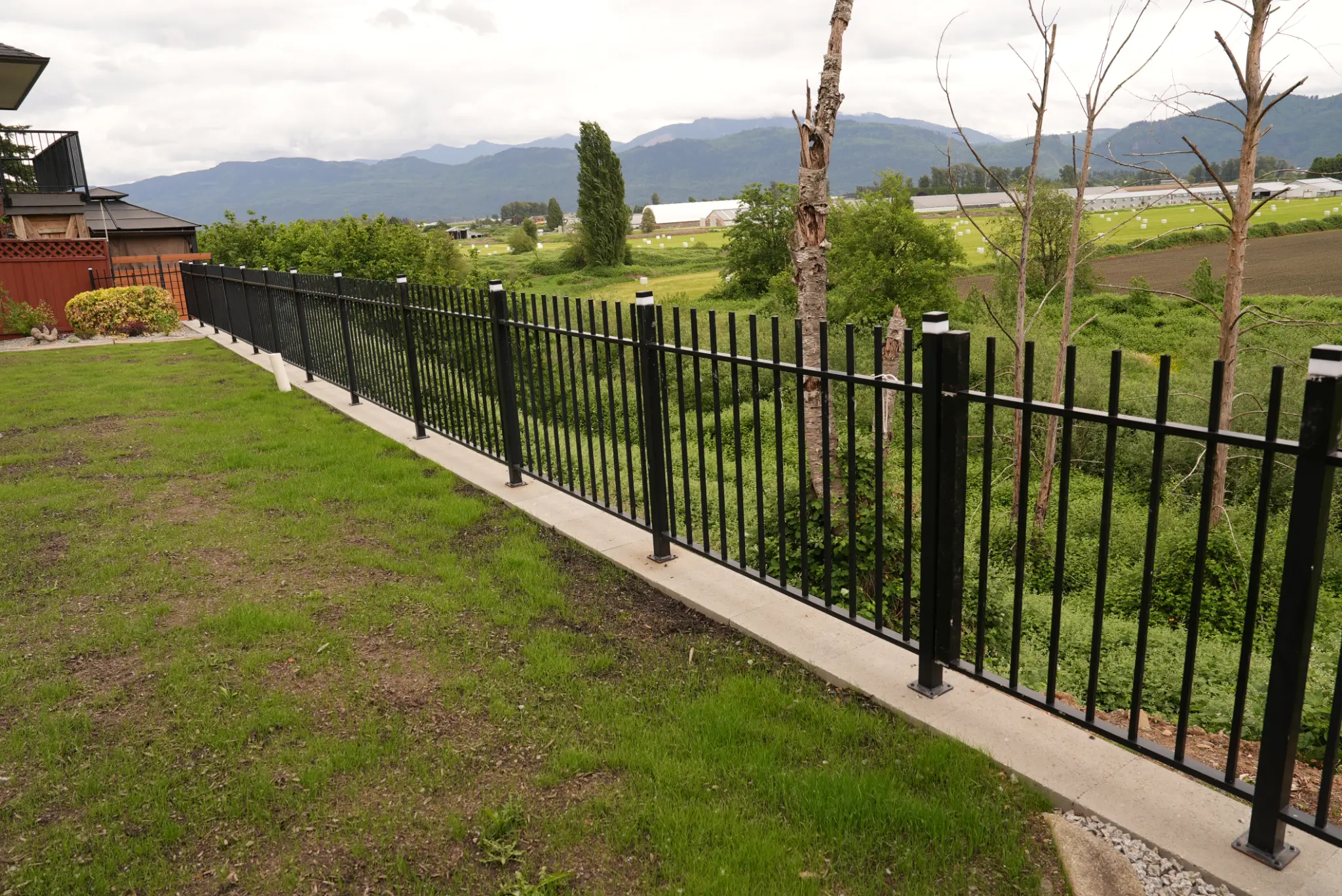 Iron fence on concrete curb with mountain views