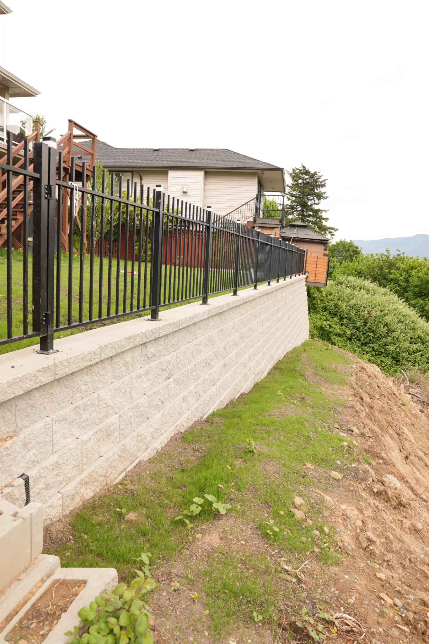 Retaining wall from side angle showing height and fencing