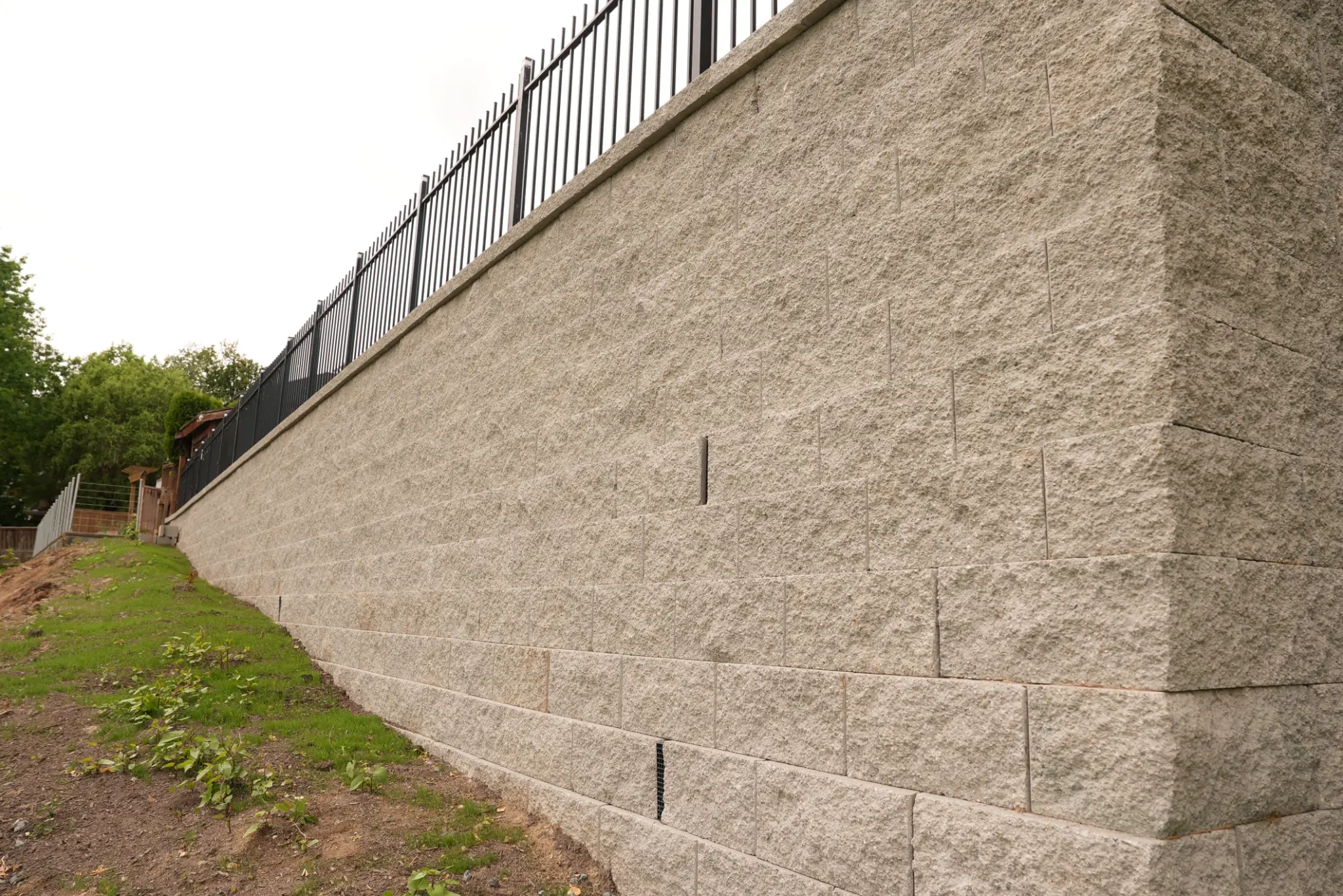 Close-up of 20-foot retaining wall showing block texture and height