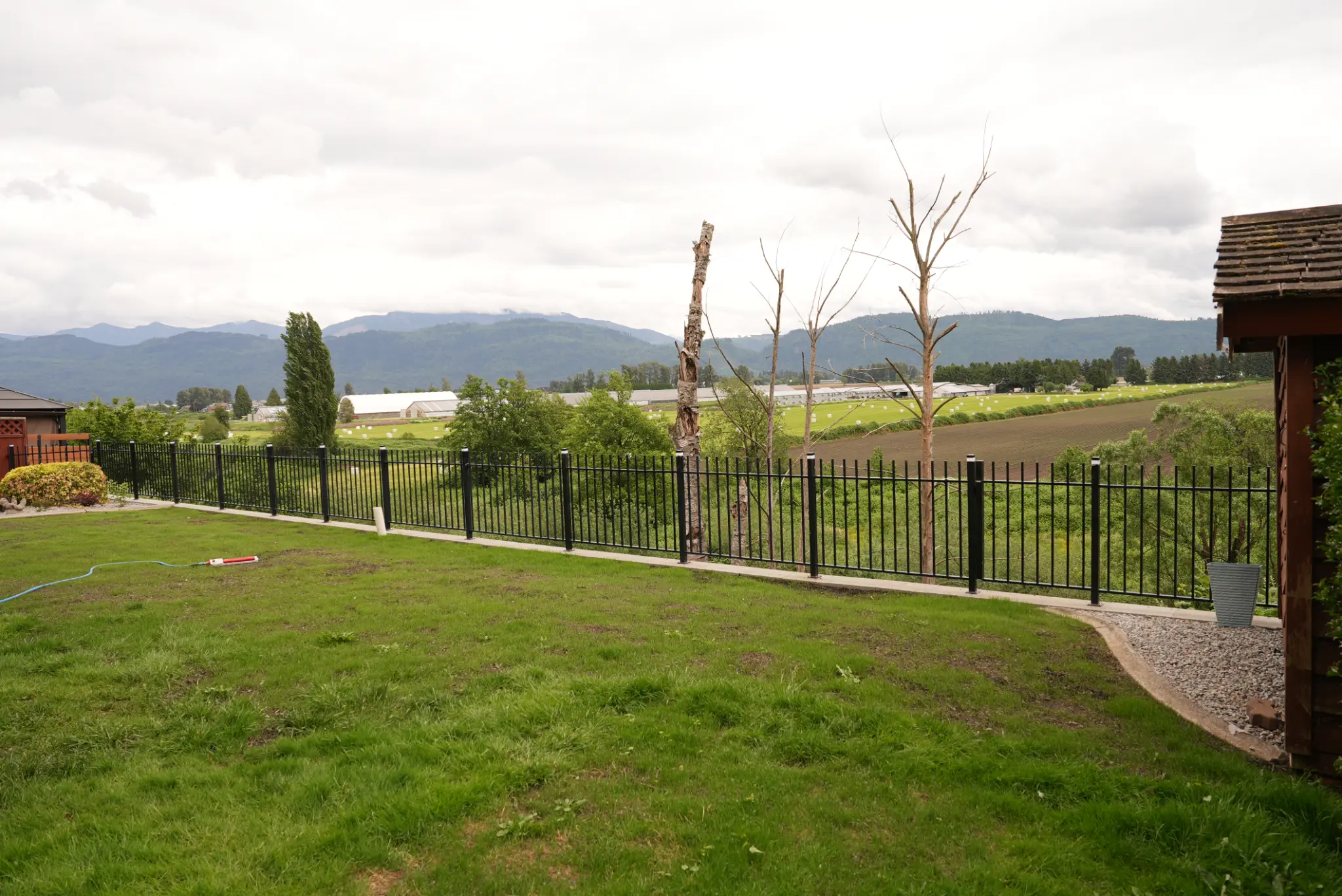 Backyard view with iron fence and Fraser Valley panorama