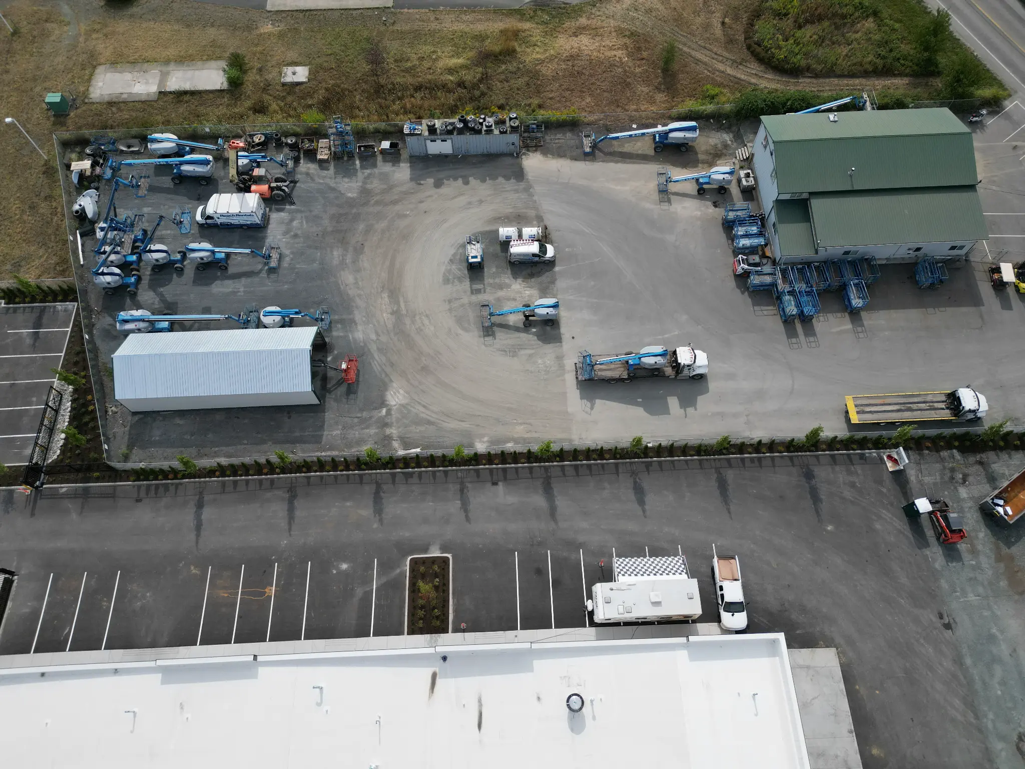 Wide aerial of the equipment yard framed by new perimeter trees and hedging