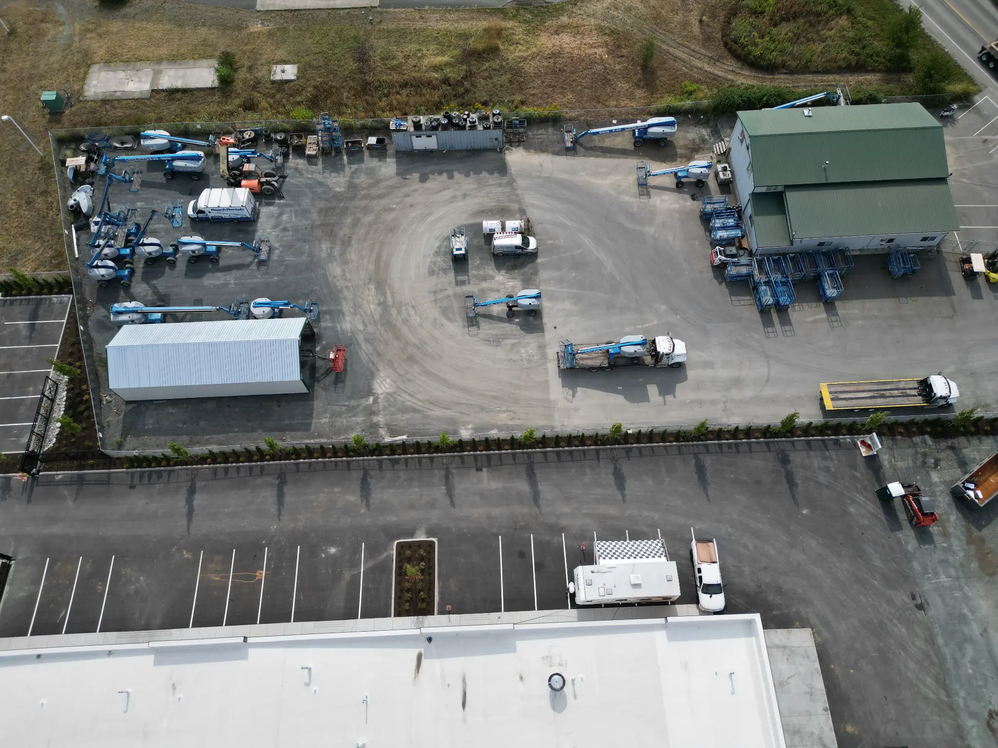 Construction-stage aerial showing site preparation and perimeter planting