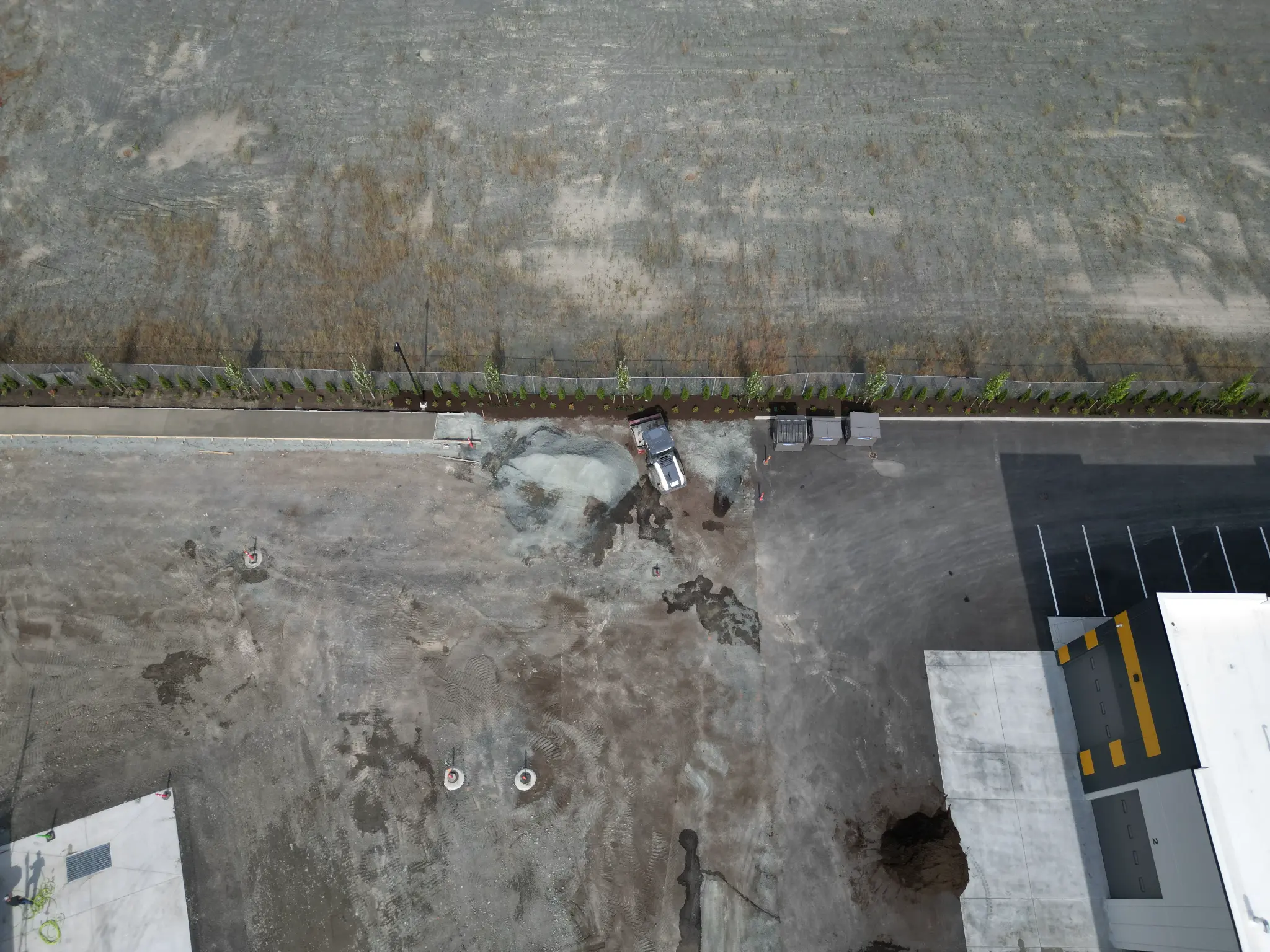 Construction progress aerial showing finished lawn and active site preparation