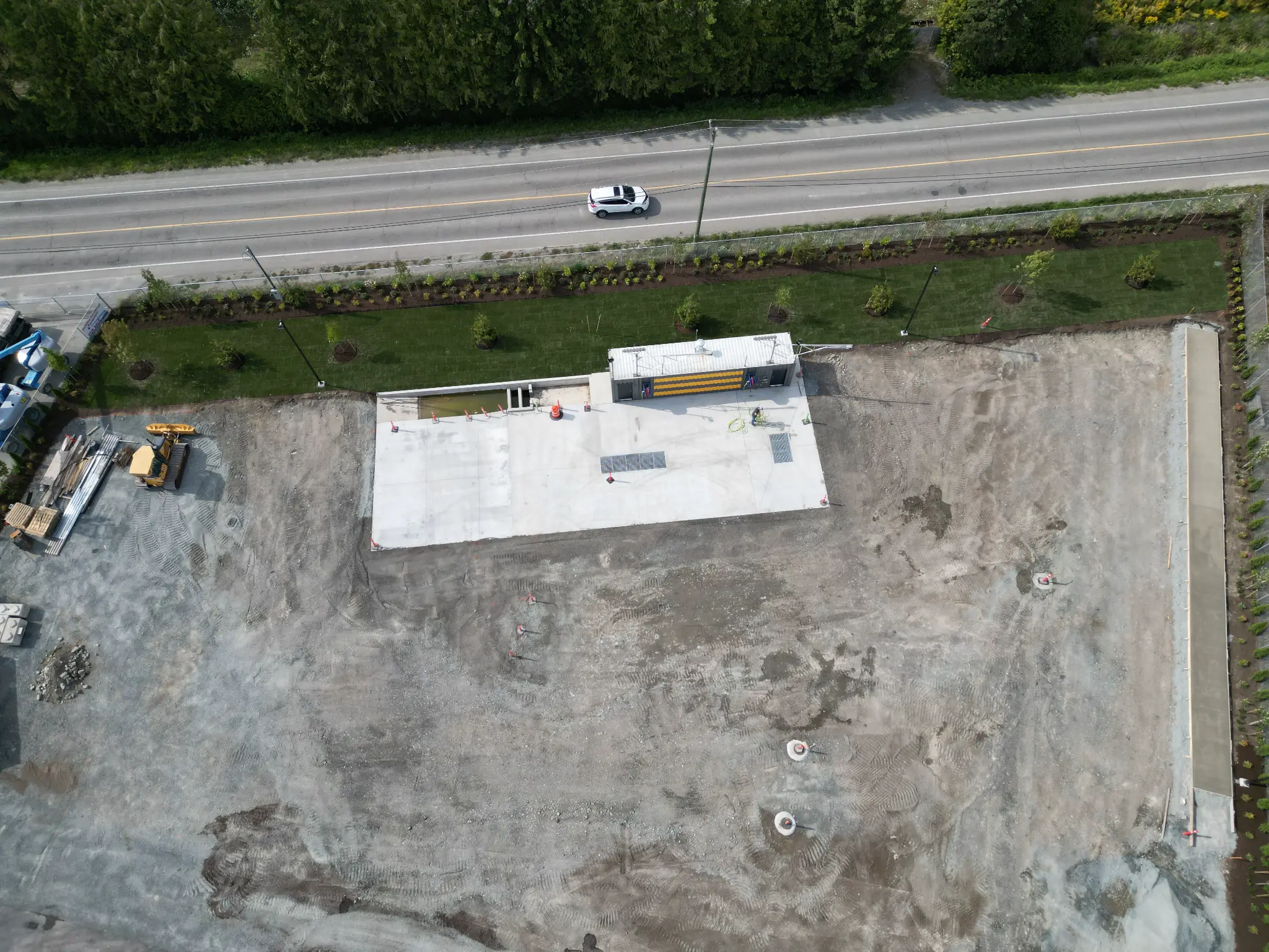 Wide construction-stage aerial with completed perimeter sod and plantings