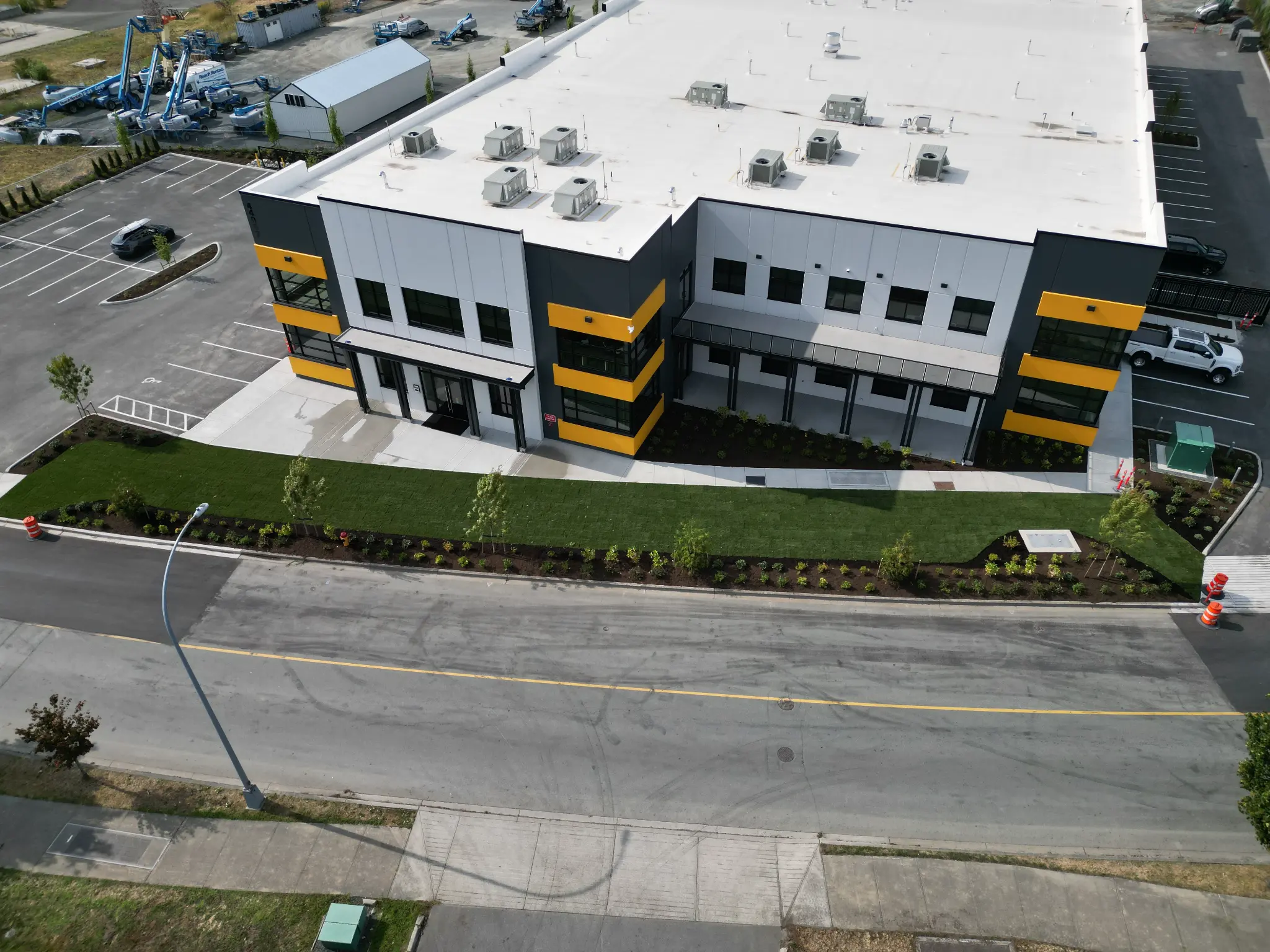 Close aerial of the completed commercial building entrance and front landscaping