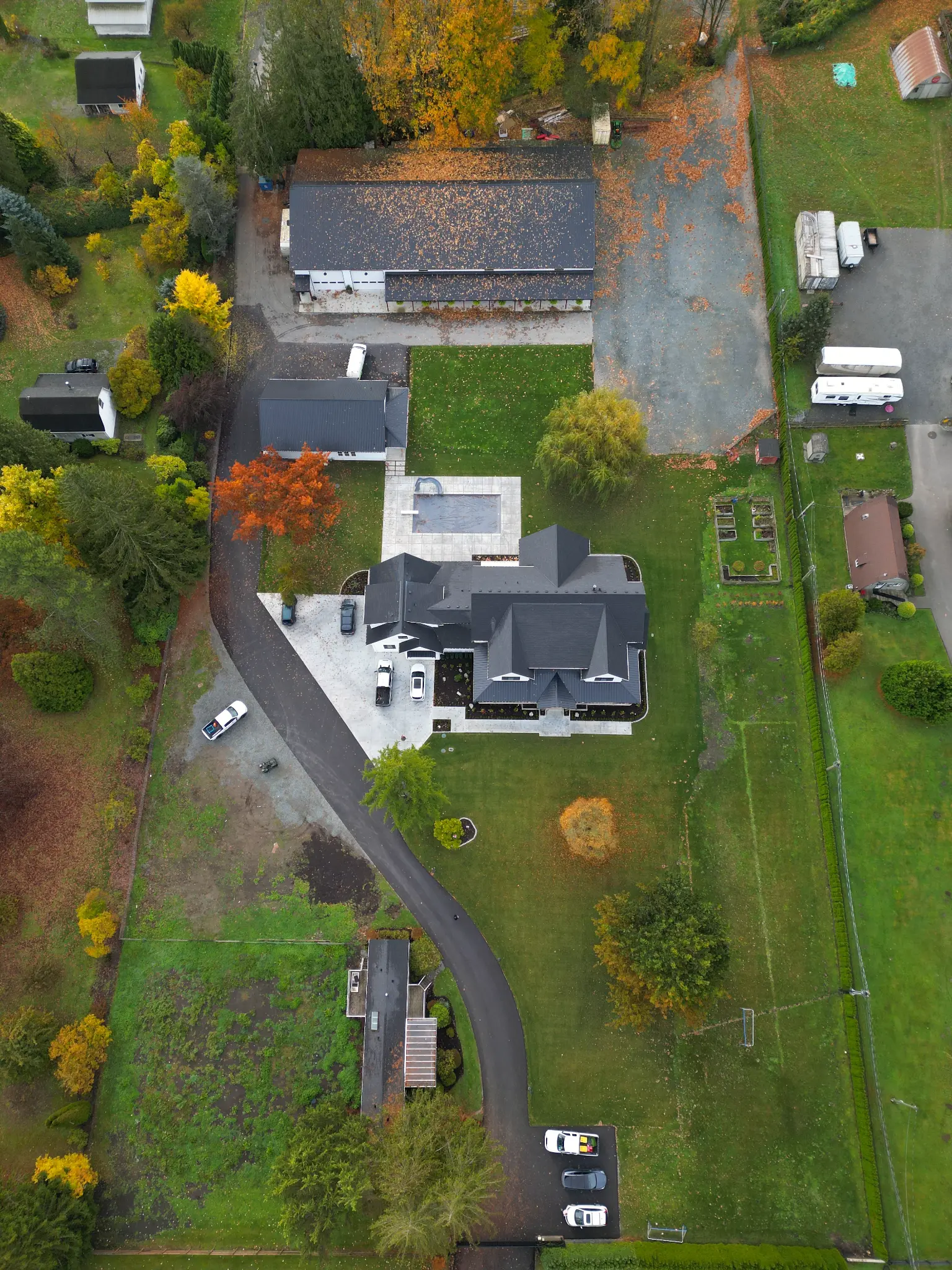 Aerial angle of the residence, lawn, and landscaped estate grounds