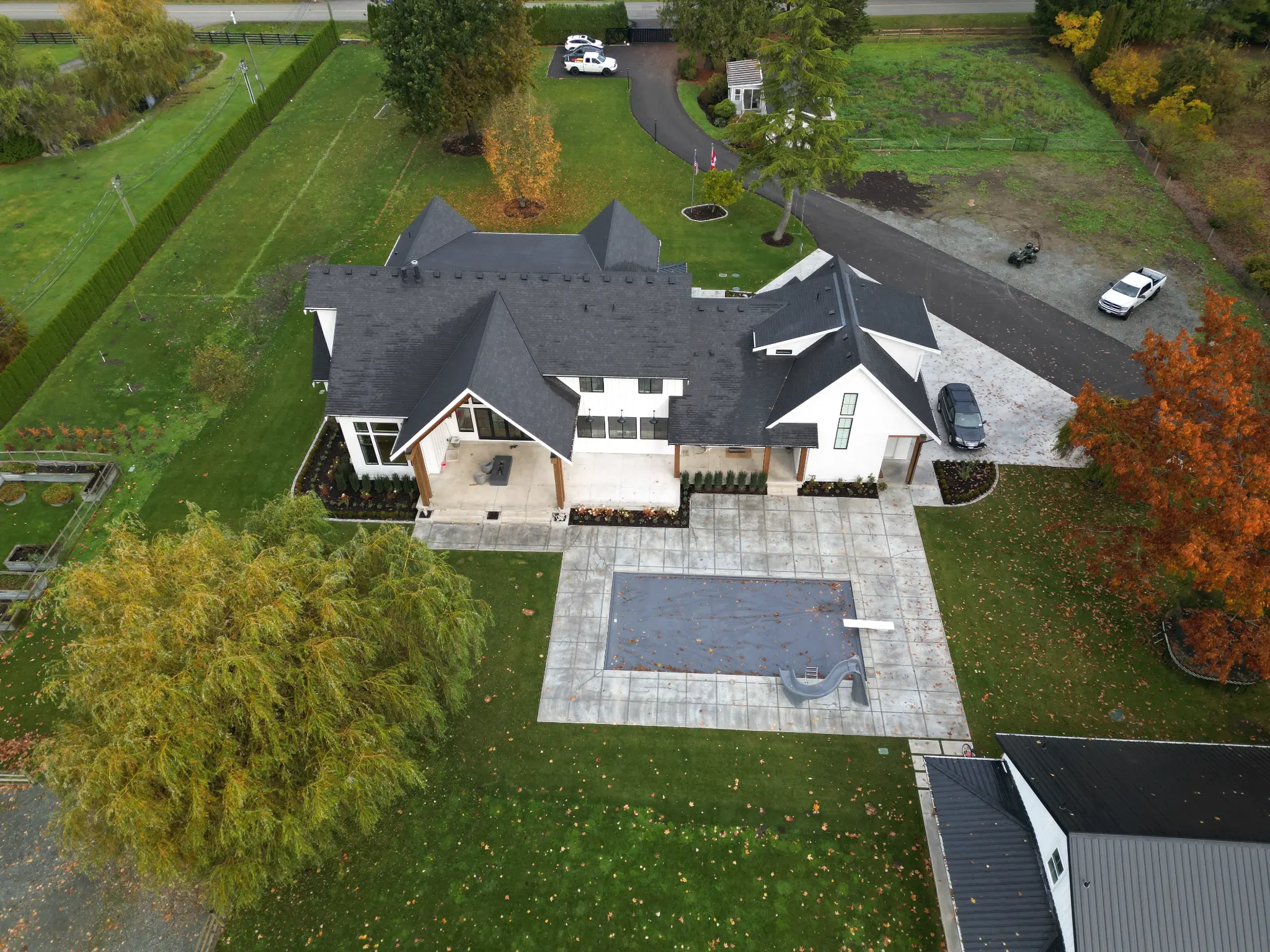 Wide estate view with lawn, garden areas, and residence