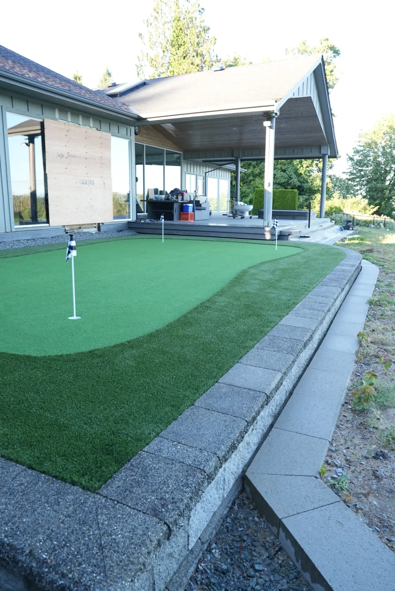 Ground-level view across the finished putting green and retaining wall