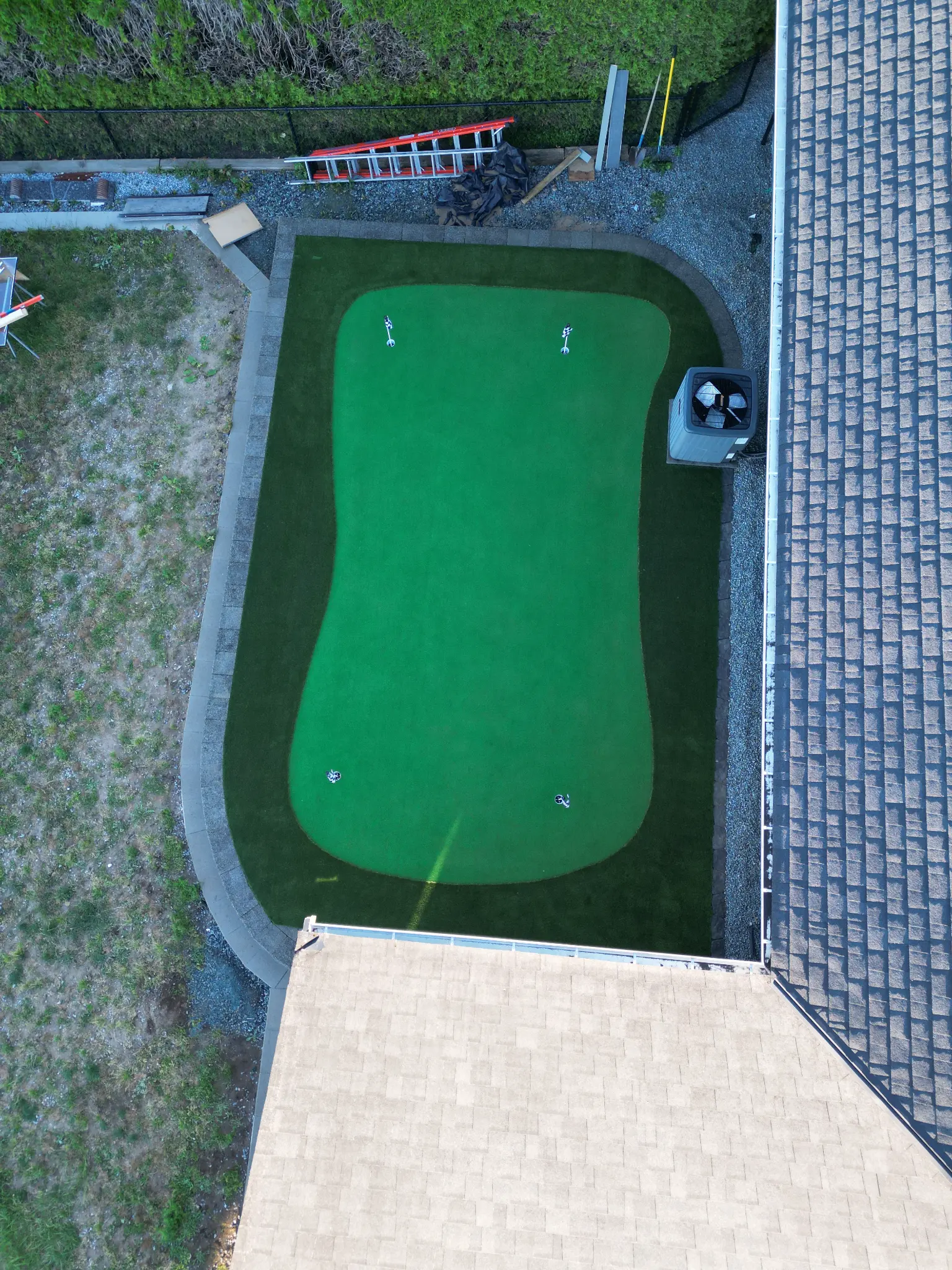 Drone view showing the completed putting green and terraced backyard