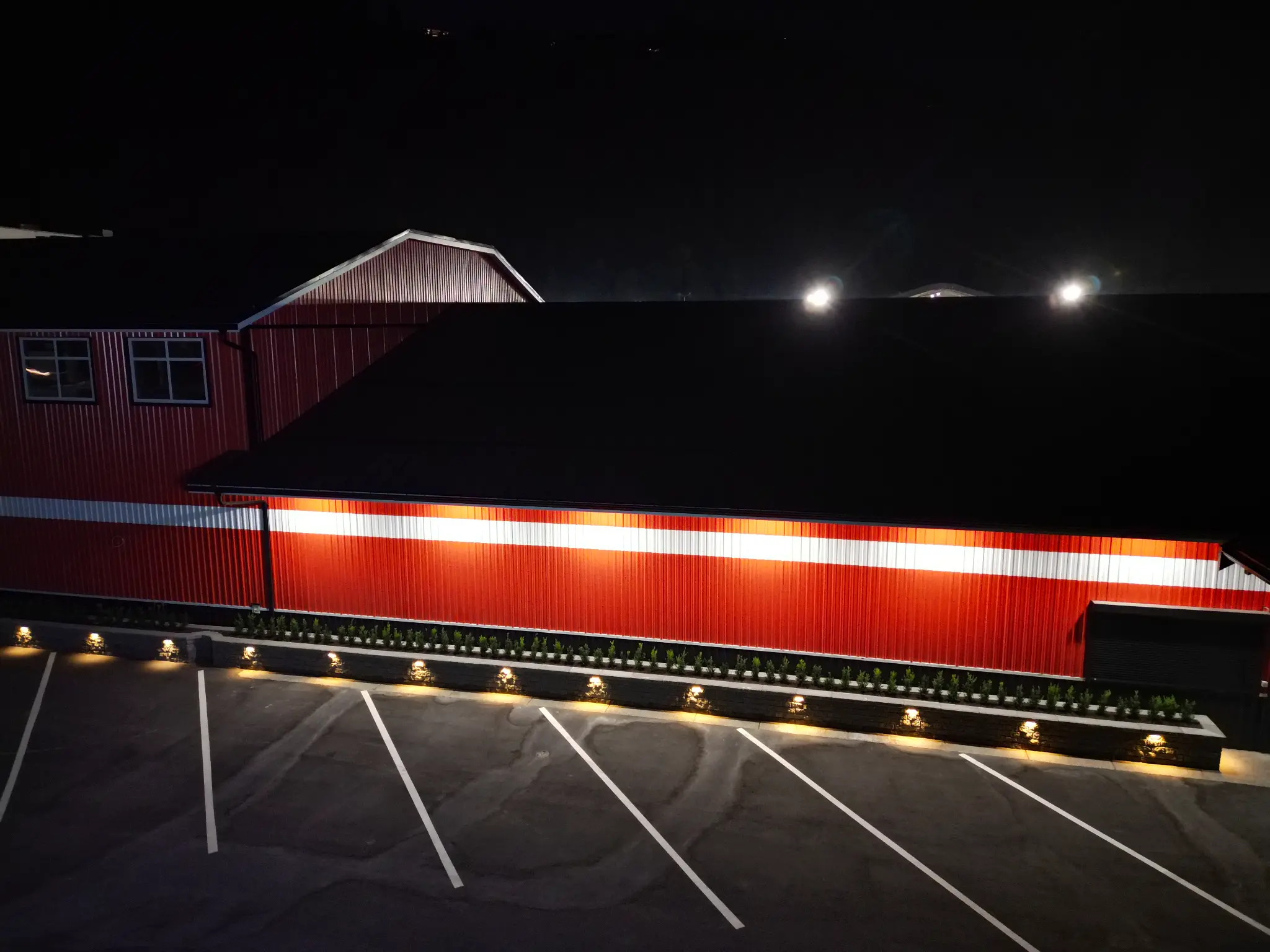 Long illuminated planter wall beside the North Coast commercial building