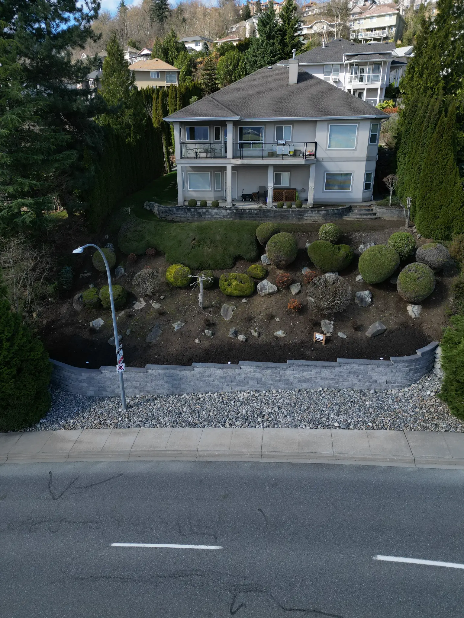 Aerial view of completed retaining wall project with landscaped hillside