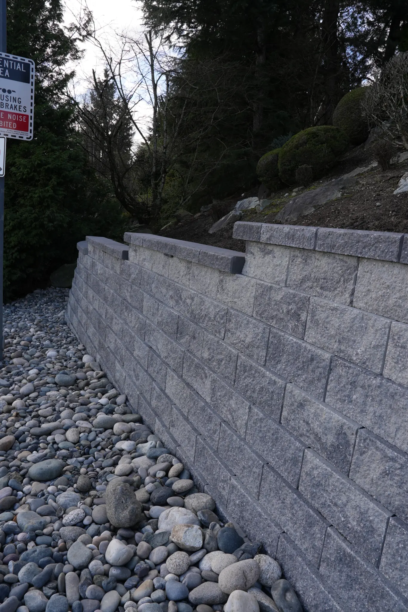Retaining wall from street level with rock base and light fixtures